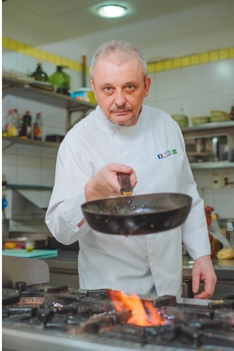 Chef Didier Labbé flambando uma panela na cozinha